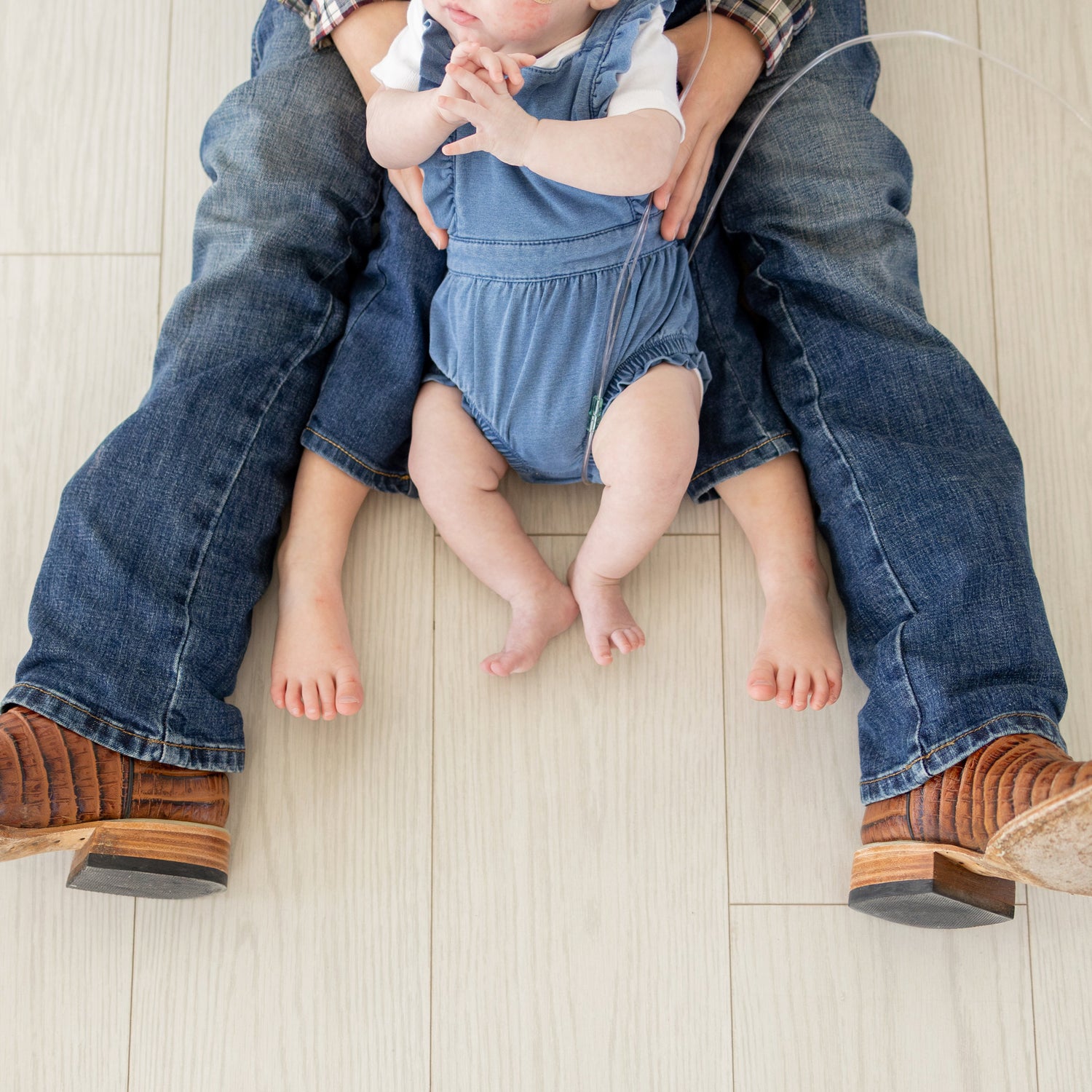 Three young children's feet, representing the family values and hometown roots of Parker County Apparel Co., a Texas-based clothing brand.